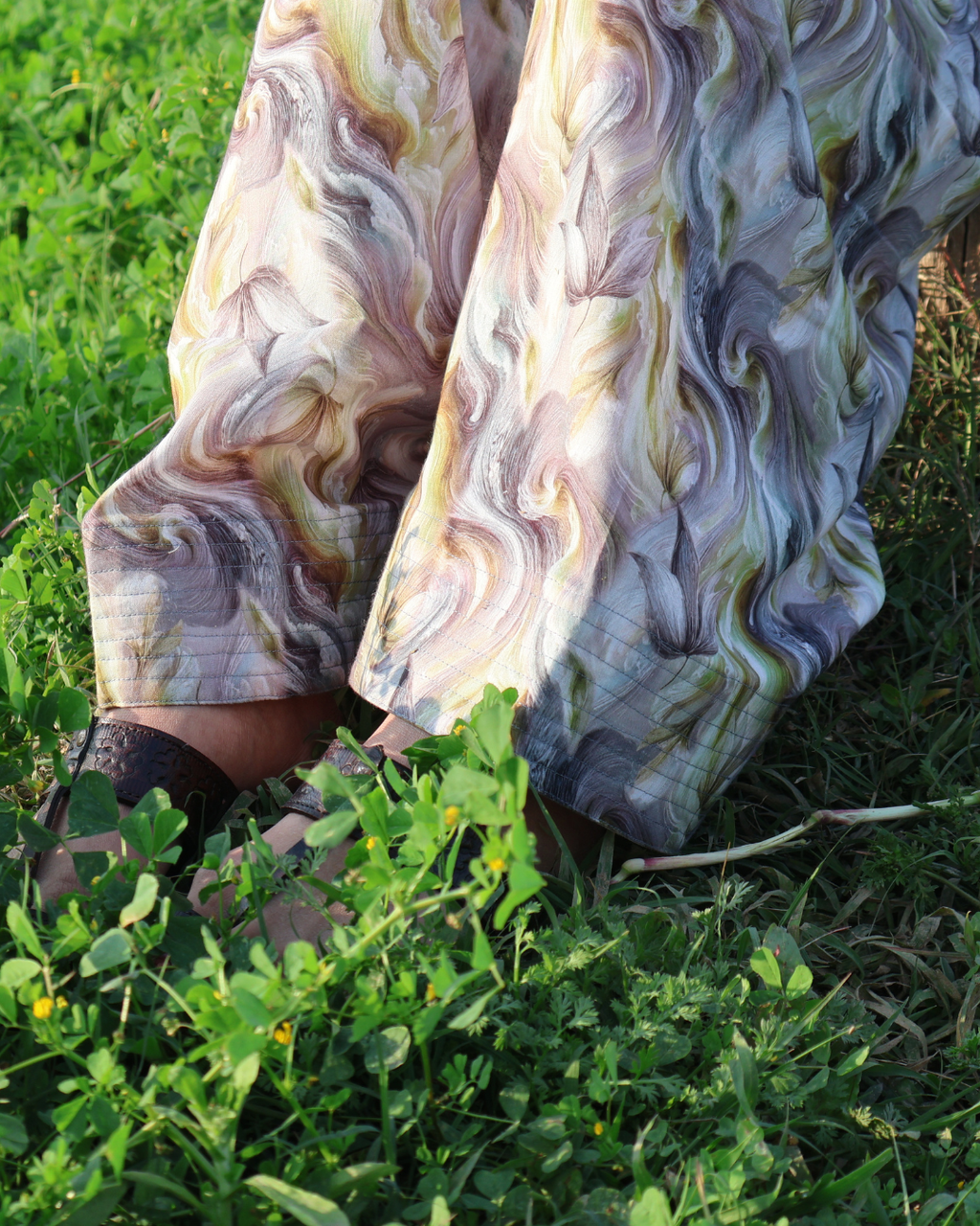 Person wearing a colorful scarf sitting on grass